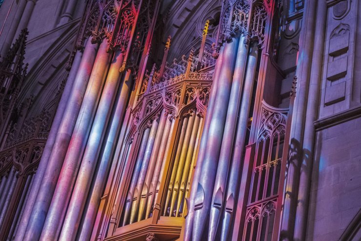 Rainbow light projected from stained glass windows illuminates pipes of the Cathedral's great organ.